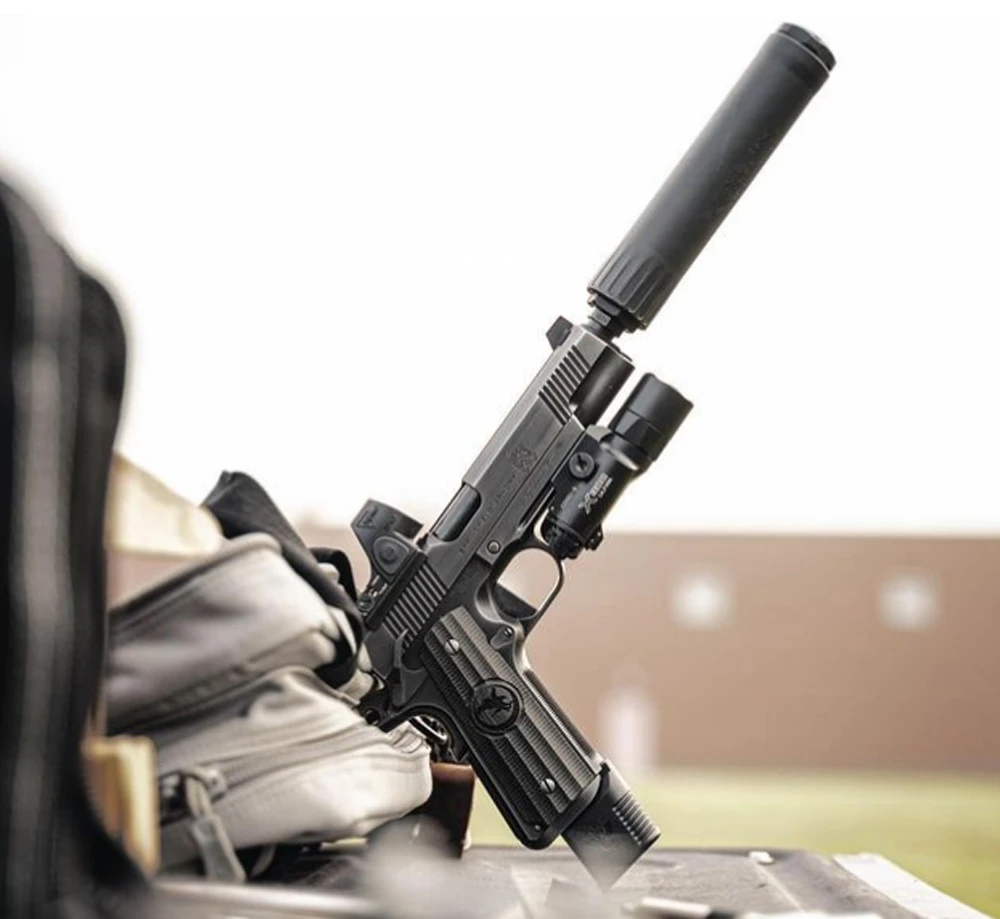 Suppressed .45 ACP pistol firing at range with modern handgun suppressor installed for reduced sound signature