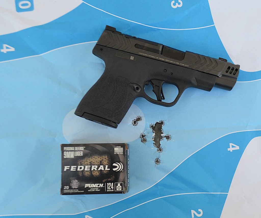 Smith & Wesson Shield Plus Performance Center Carry Comp 9mm pistol shown with target at close range