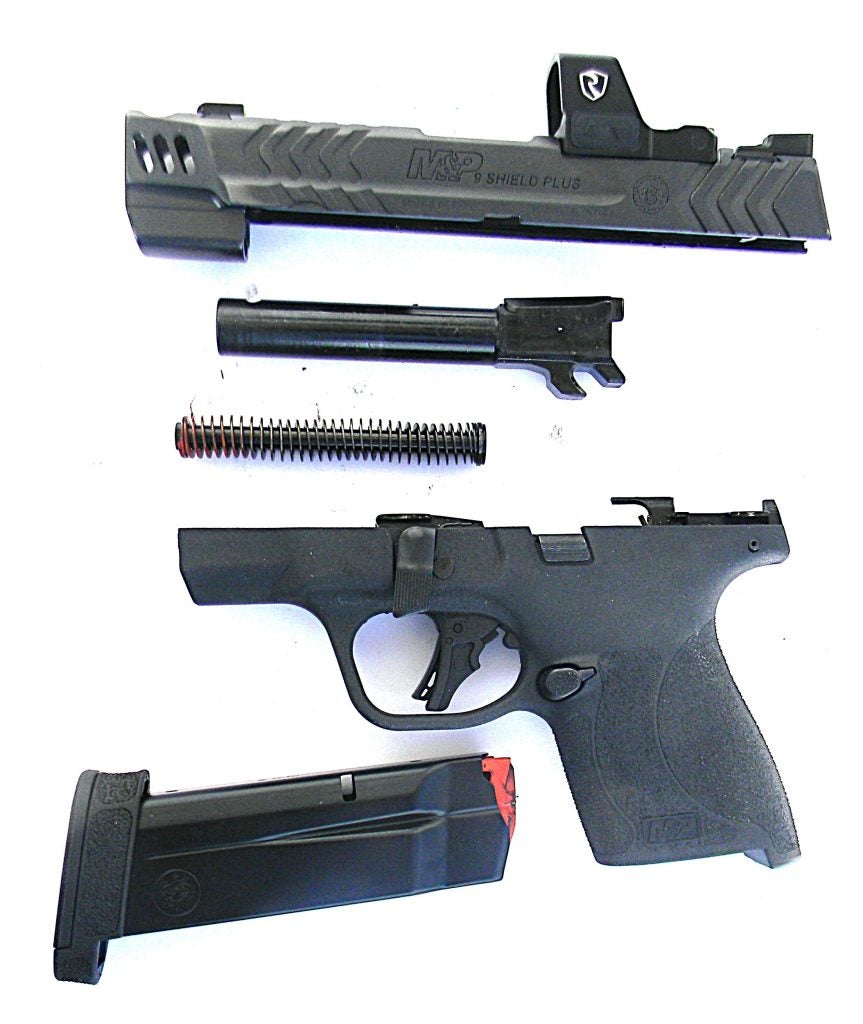 Smith & Wesson Shield Plus Carry Comp field stripped for cleaning, showing slide, barrel, and frame