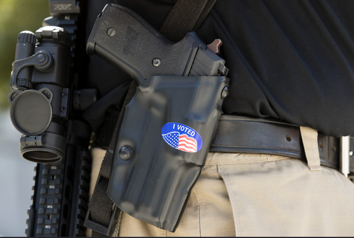 Gun rights advocate wearing an I Voted sticker on his holster at the Pennsylvania Capitol