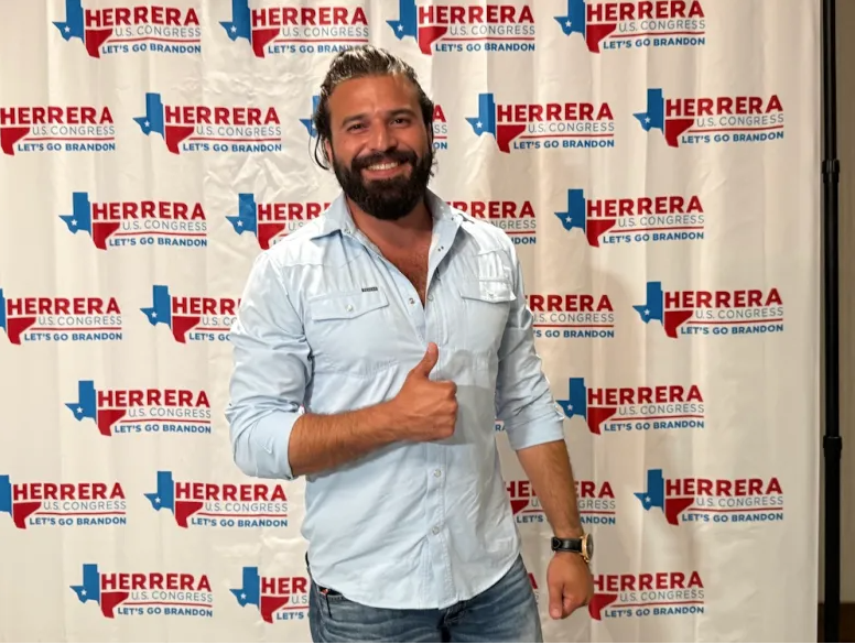 Brandon Herrera giving a thumbs-up in front of Herrera for U.S. Congress campaign event.