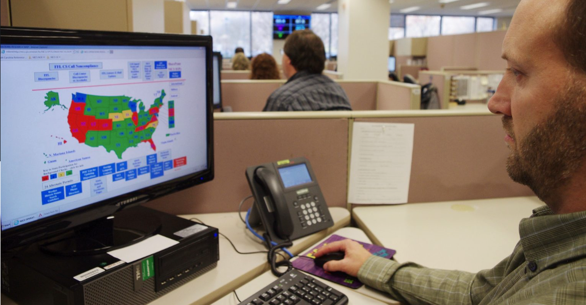 FBI background check examiner working at a computer at the Criminal Justice Information Services center in West Virginia