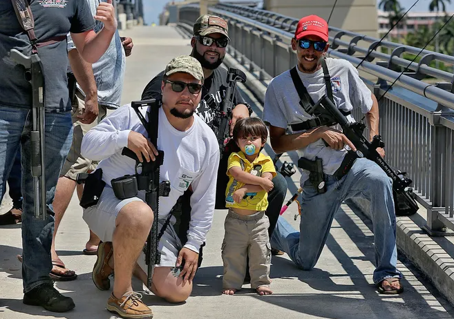 Armed men openly carrying rifles while walking outdoors in Florida