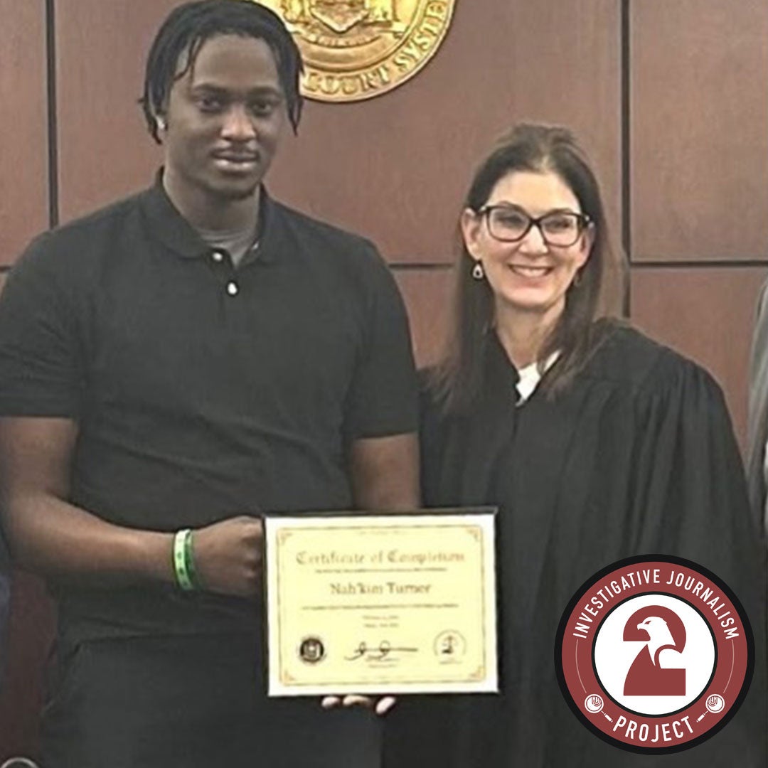 Demetrio Daga standing beside a judge while holding a certificate