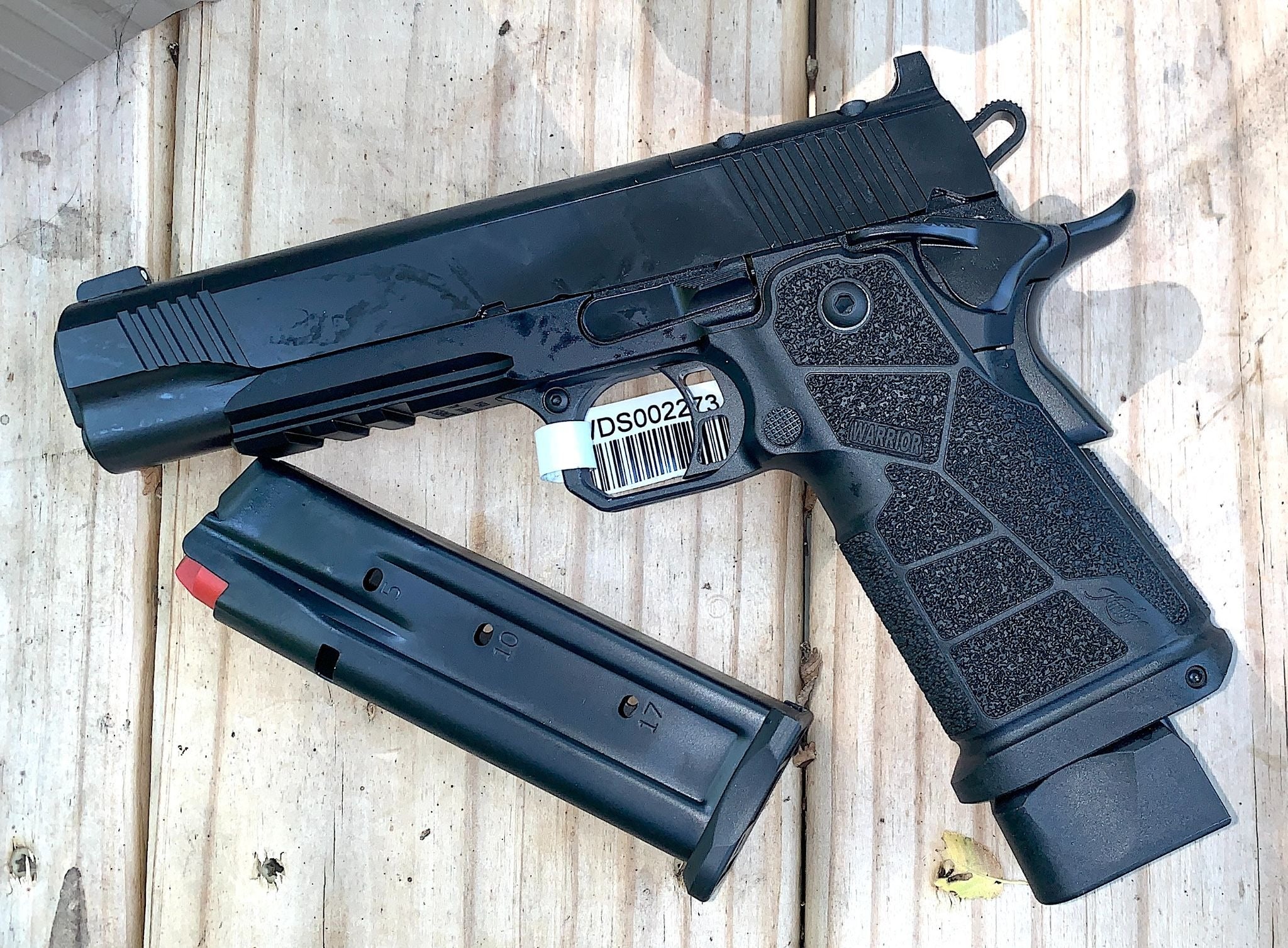 Kimber DS Warrior 9mm double-stack 1911 pistol with black finish, textured grip and extended magazine on a wooden surface.